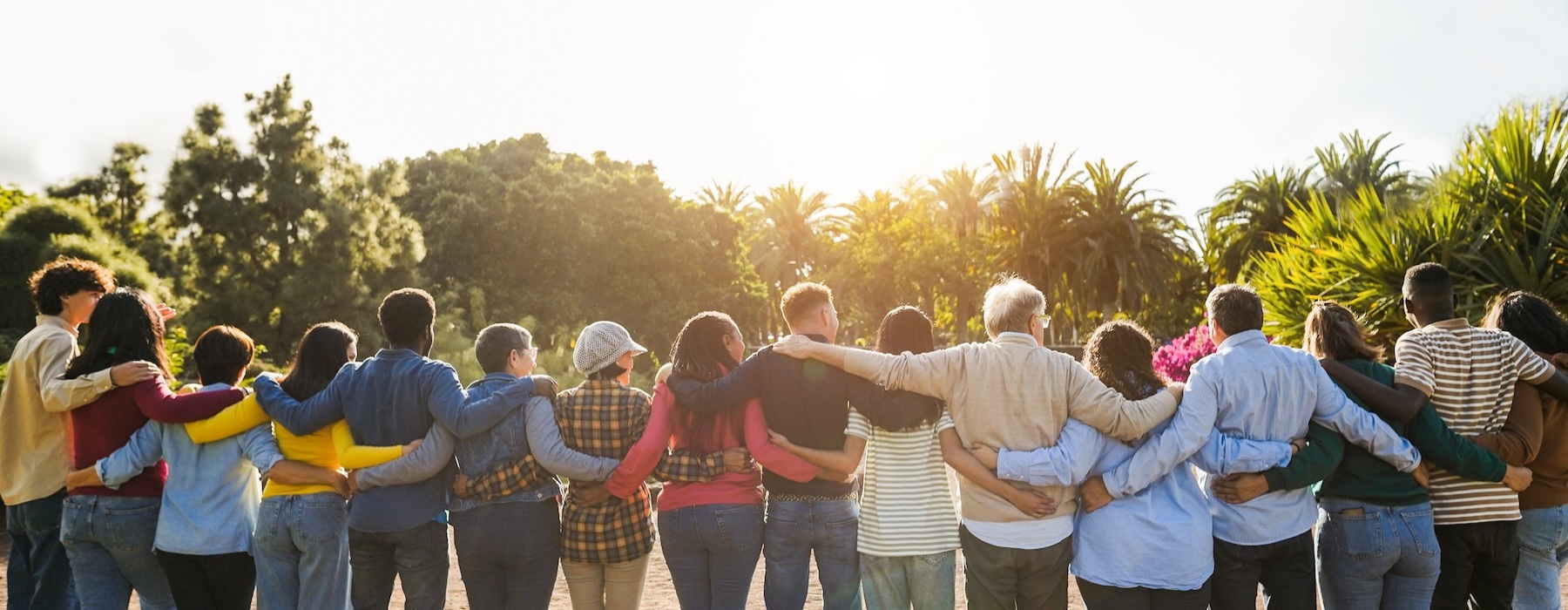 a group of people locking arms and looking toward the sunlight